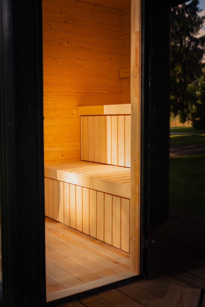 Innenraum der finnischen Sauna im Komplex KOTI L – zweistufige Bänke aus hellem Holz und Wände aus Brettern